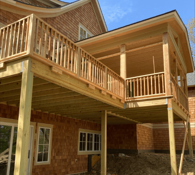 A large wooden deck with a railing and stairs.