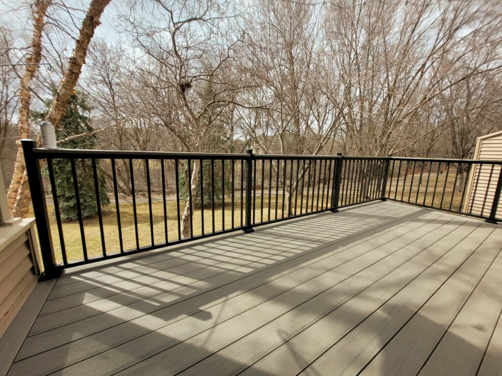 A deck with a view of the trees and the woods.