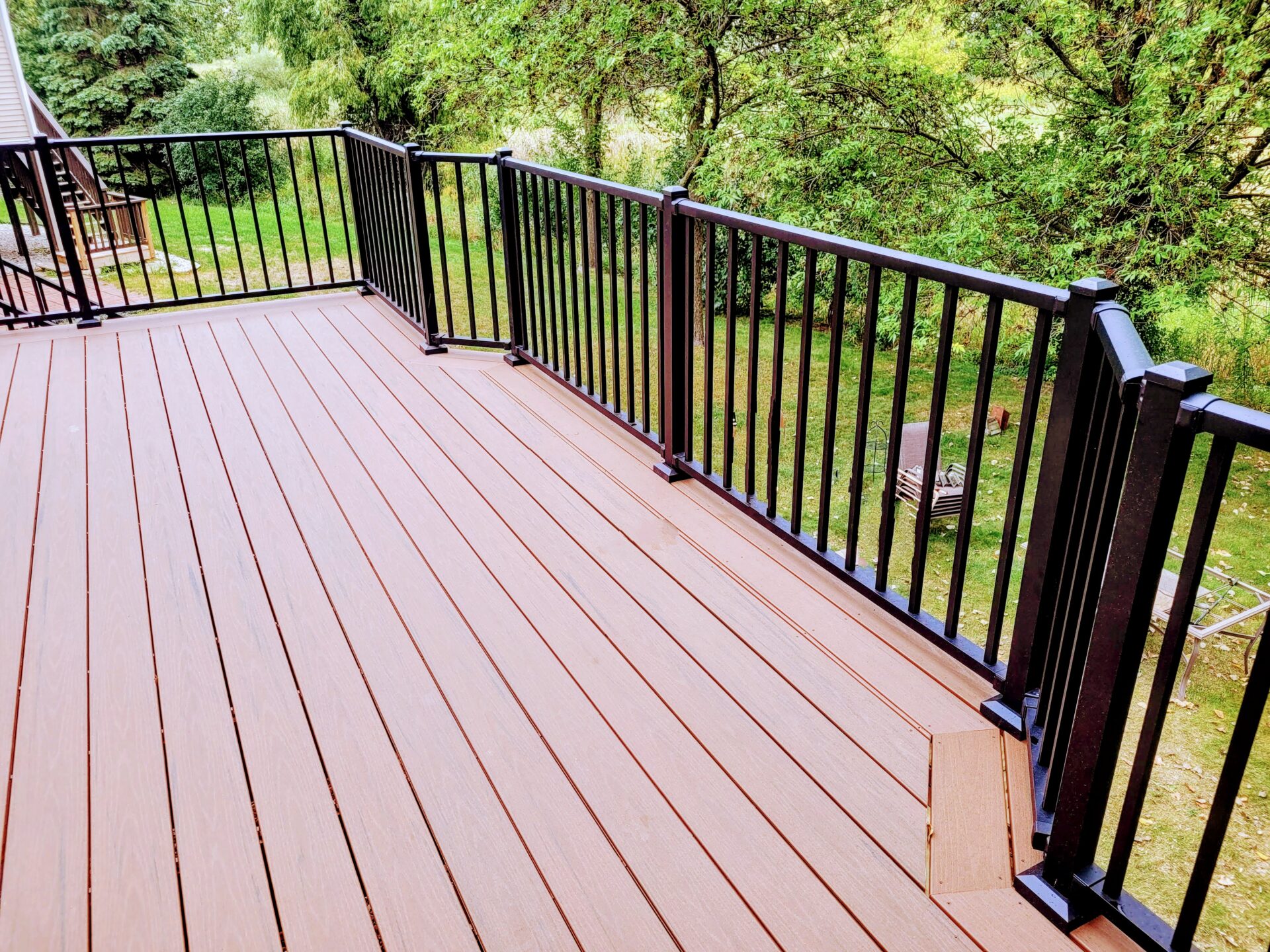 dark deck, black railing, long view backyard