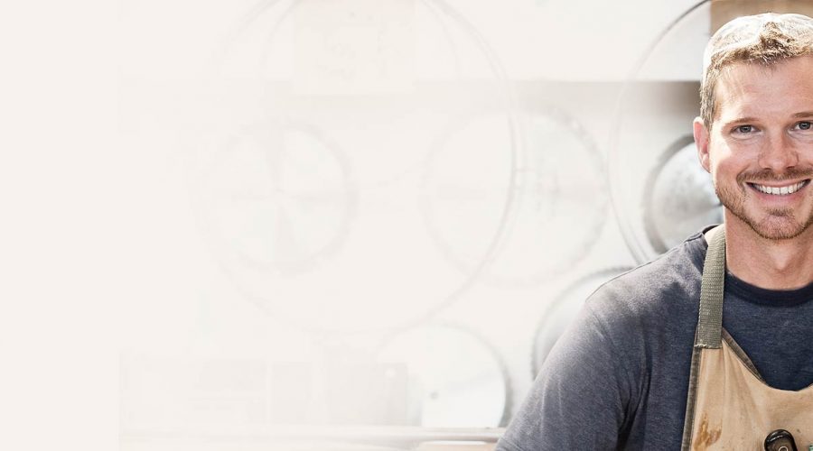 A person sitting in front of a window with clocks behind them.