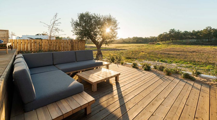 A wooden deck with a couch and table on it