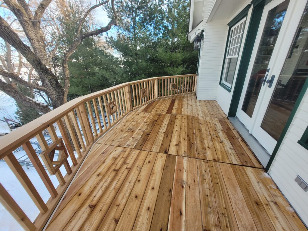 A wooden deck with a view of the back yard.