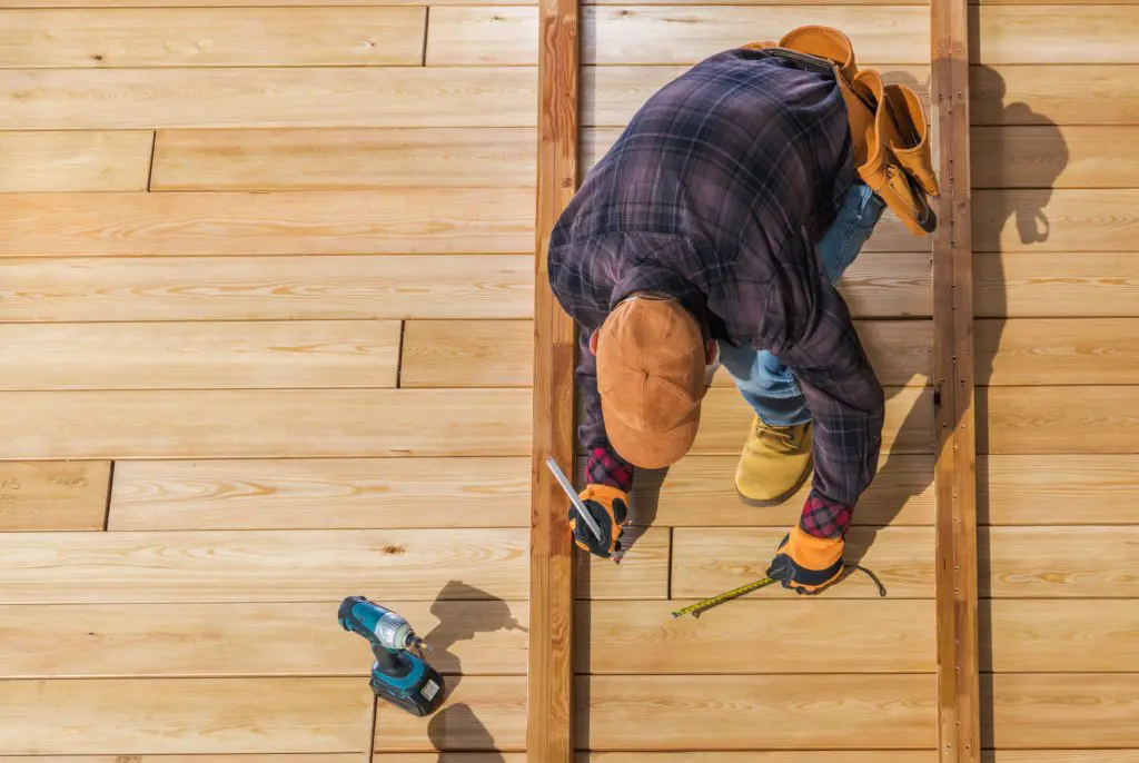 A man working on the floor of a house.