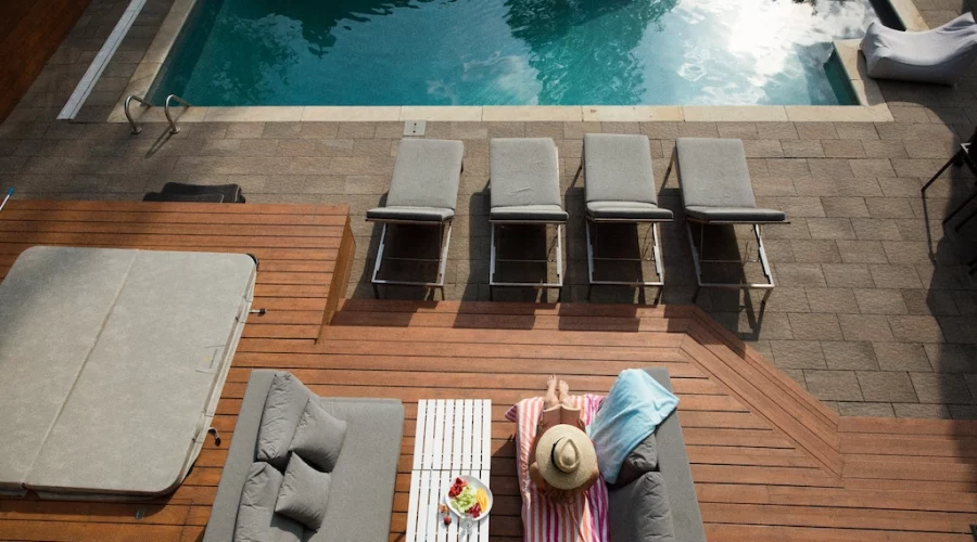 A pool with chairs and tables next to it