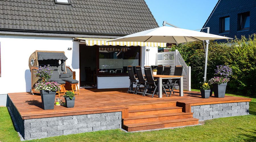 A patio with an umbrella and table in the middle of it