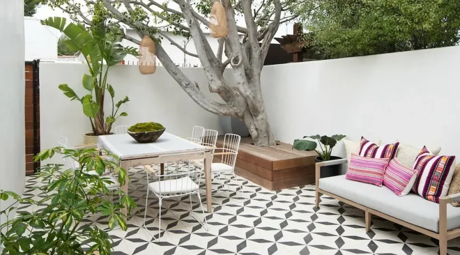 A patio with a table, chairs and a bench.