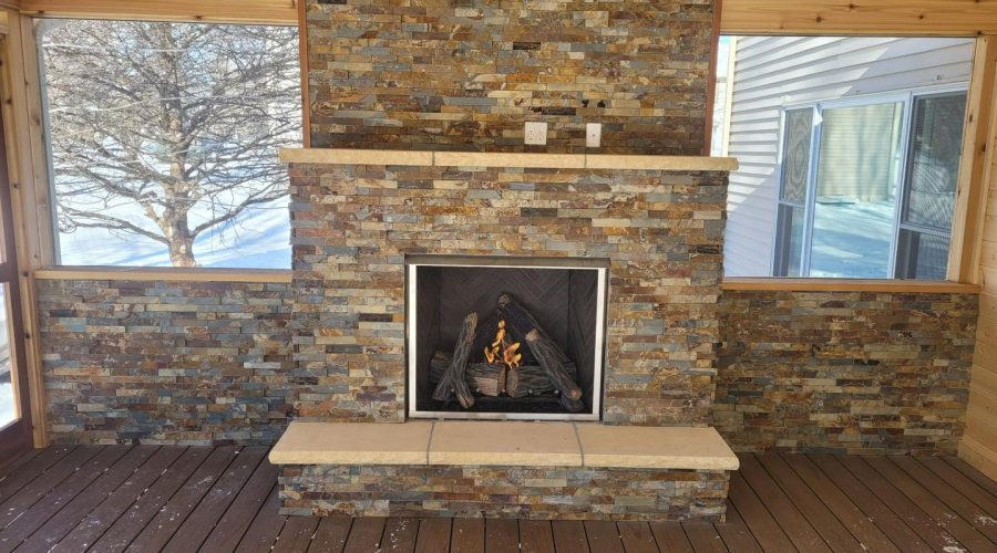 A fireplace with stone and wood in the middle of a porch.