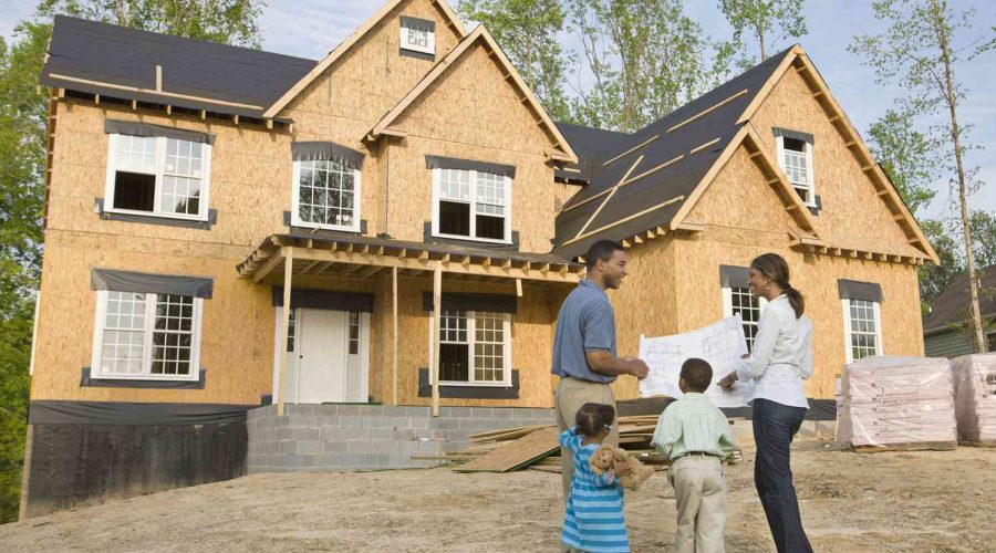 A family standing in front of their new home.