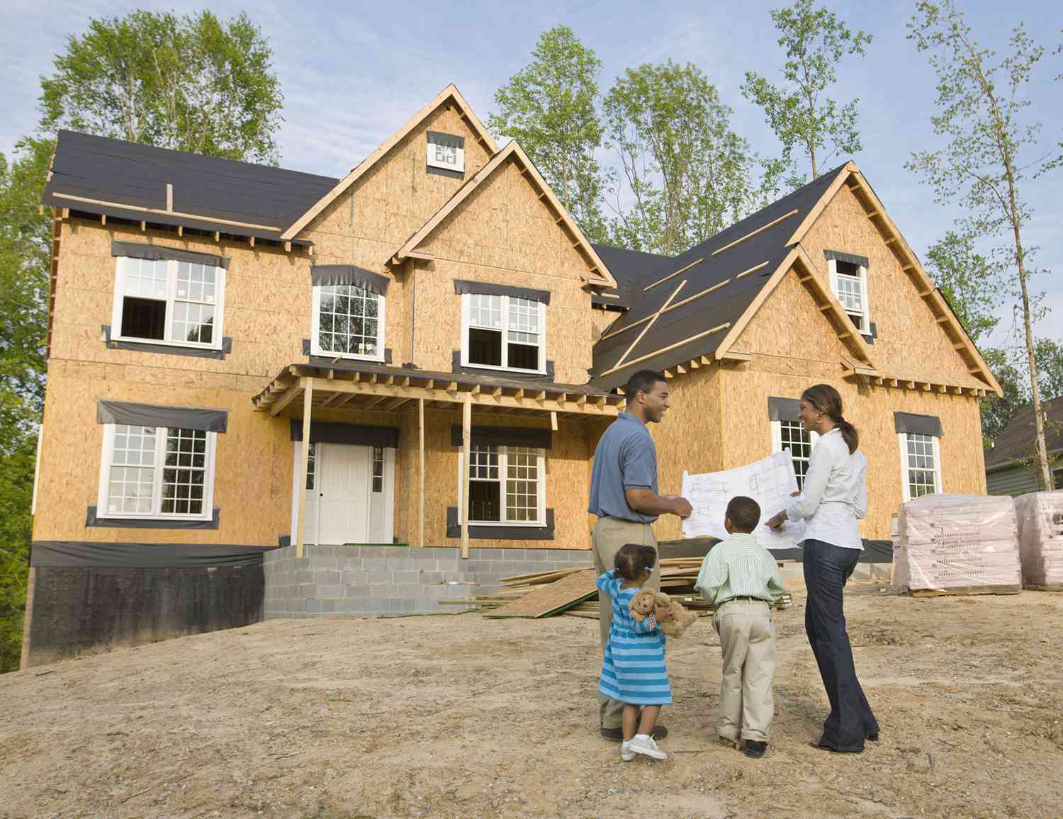 A family standing in front of their new home.