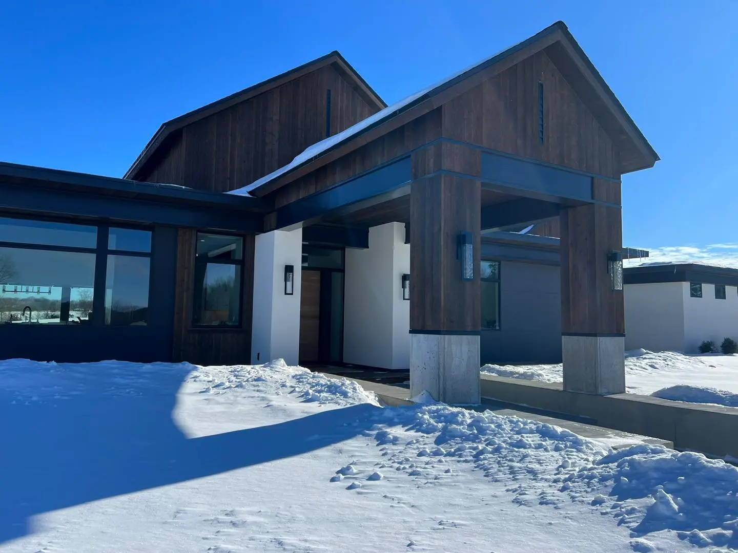 A house with snow on the ground and blue sky