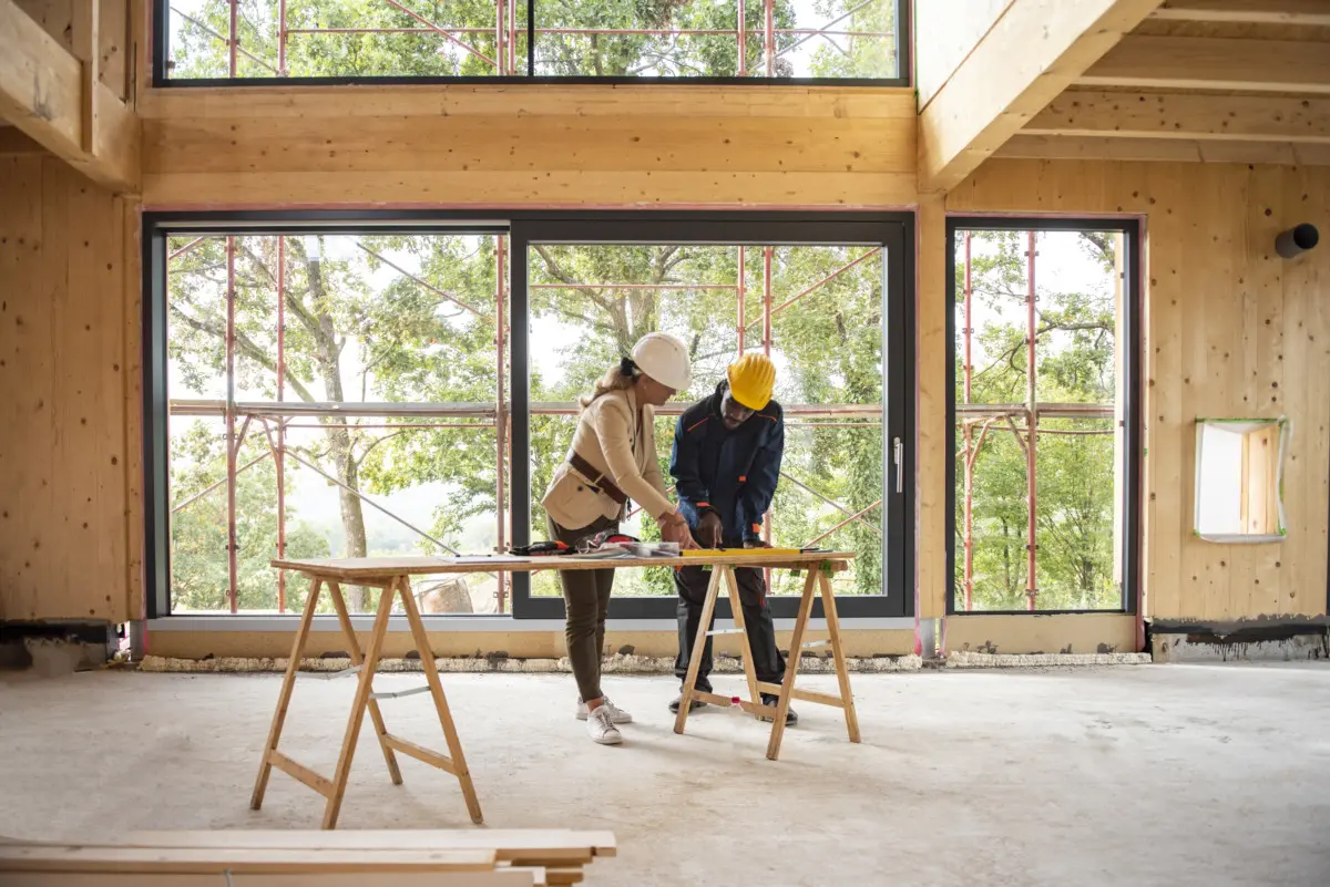 Two people working on a project in front of windows.