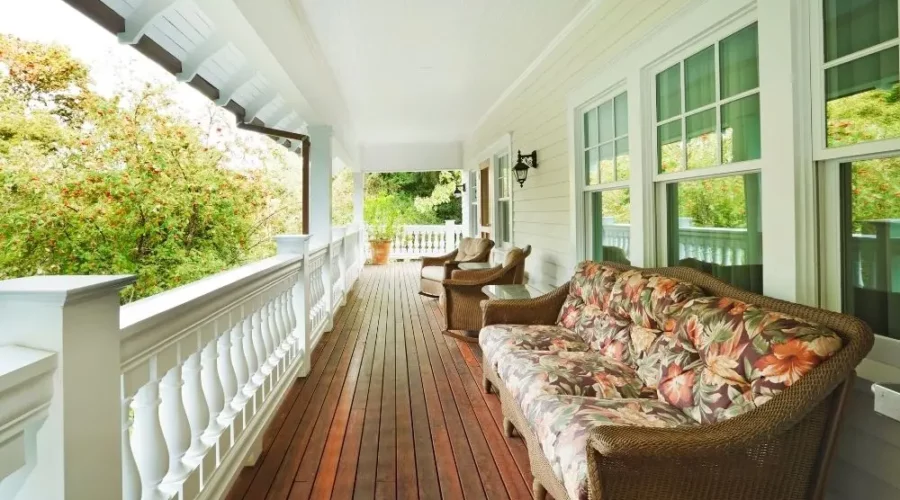 A porch with many couches and chairs on it