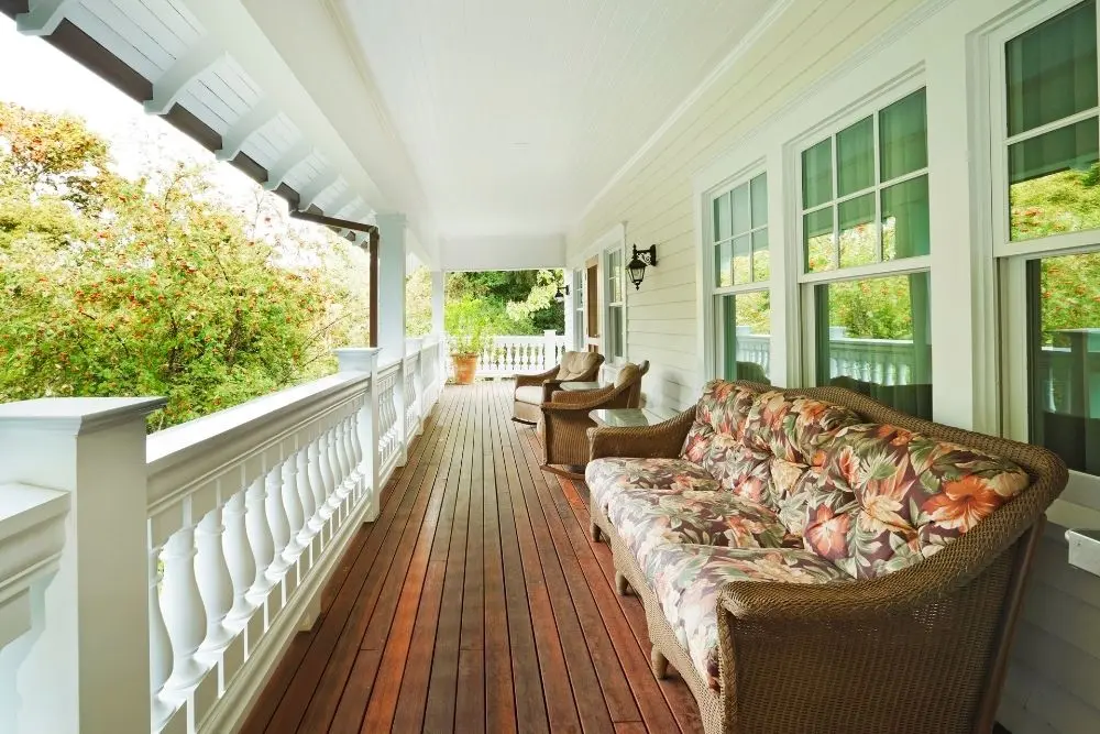 A porch with many couches and chairs on it