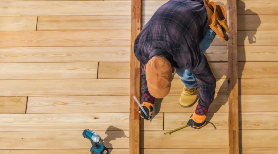 A man working on the floor of a house.