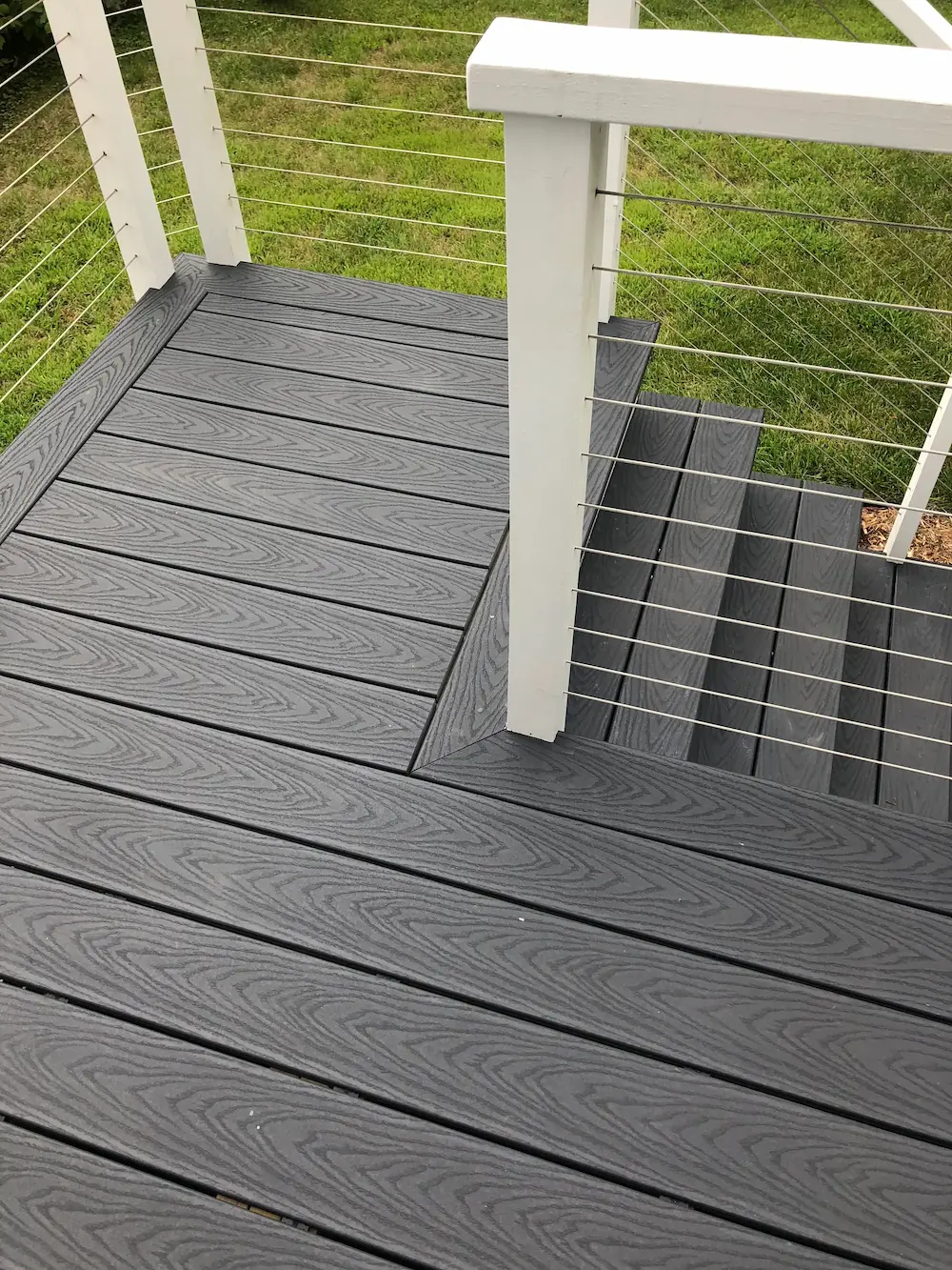 A deck with a railing and stairs on it.