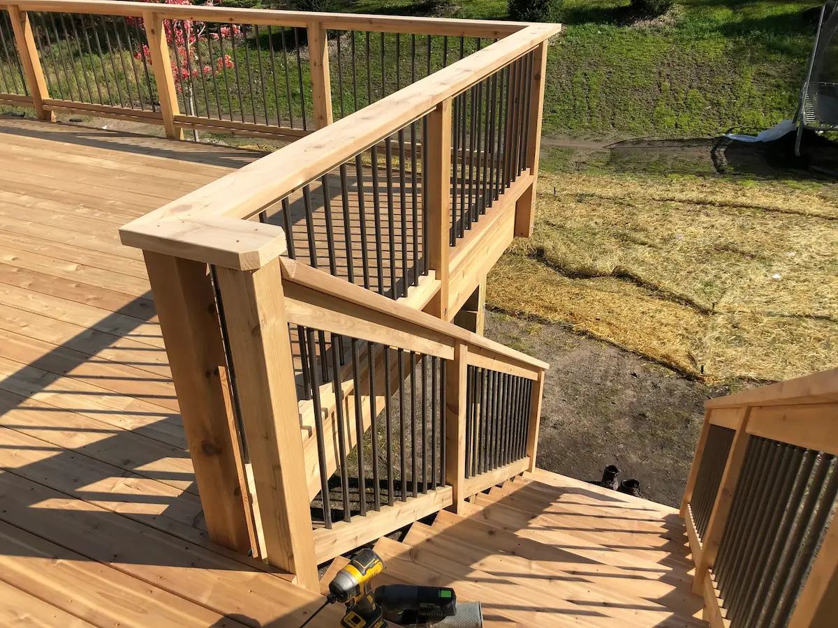 A wooden deck with stairs and railings.