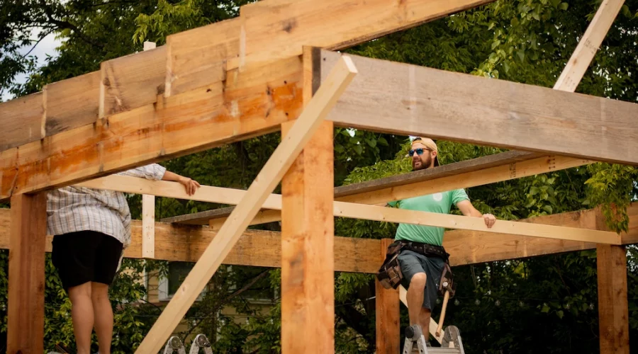 Two men working on a wooden structure.