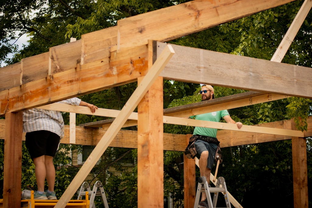 Two men working on a wooden structure.