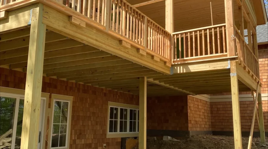 A house with a deck and stairs going up the side.