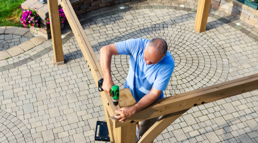 A man is working on the top of a wooden structure.