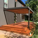 A wooden deck with steps leading to the back patio.