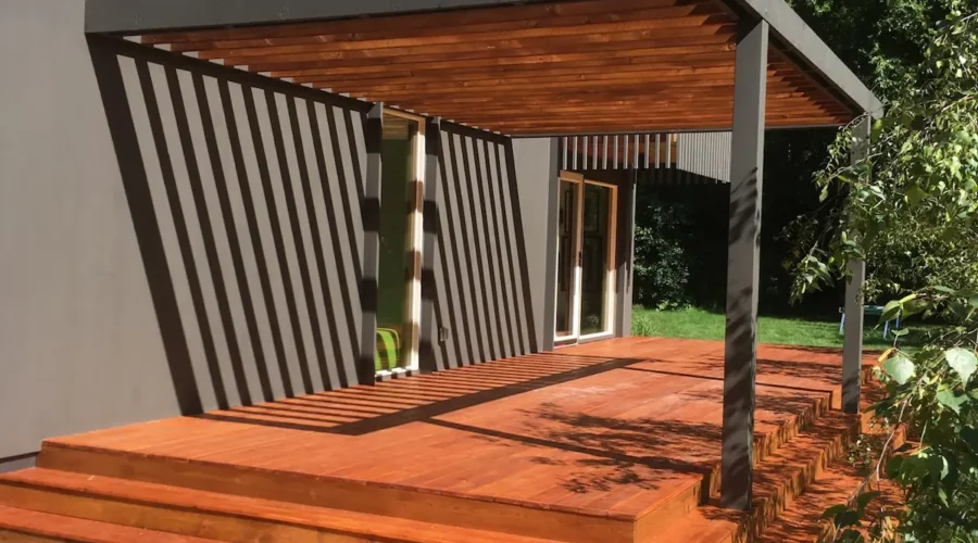 A wooden deck with steps leading to the back patio.