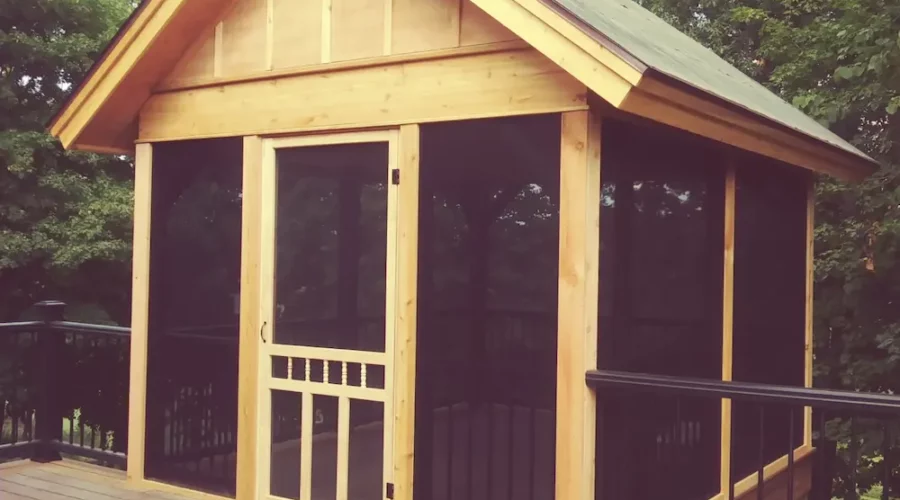 A wooden shed with black doors and windows.