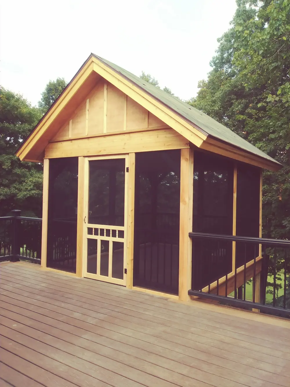 A wooden shed with black doors and windows.