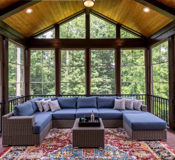 A large covered patio with blue furniture and a table.