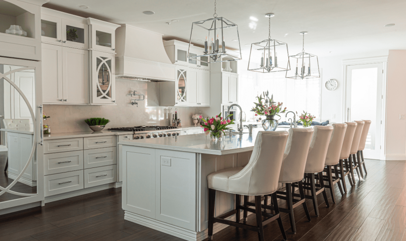 A kitchen with white cabinets and a large island.