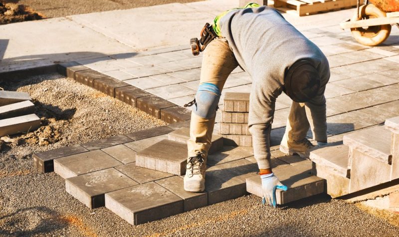 A person in safety gear working on brick steps.