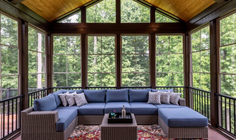 A large covered patio with blue furniture and a table.